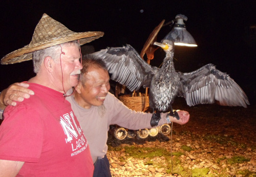 Wayne poses with the fisherman and the Cormorant fisher-bird.